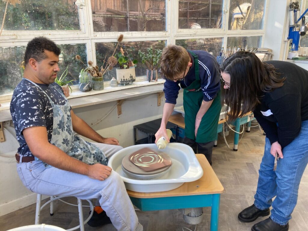 Members at pottery wheel