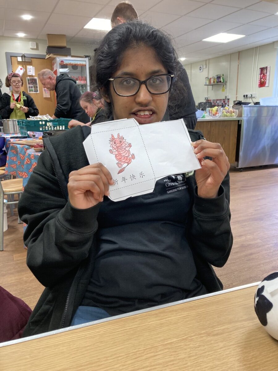 Member holding a handmade red envelope
