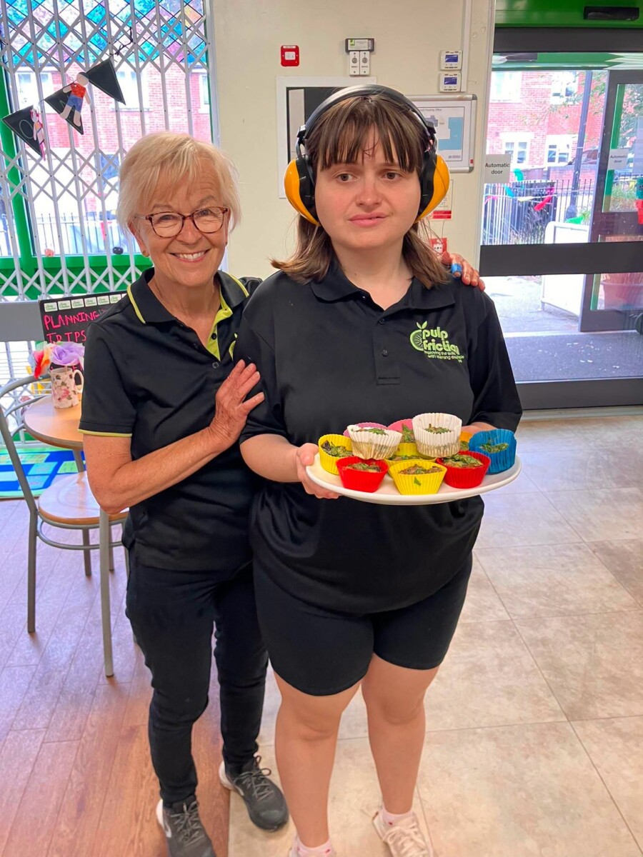two women standing with a tray of egg muffins